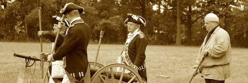 Revolutionary War Reenactment at Sir William Johnson Hall showing soldiers in uniform and cannon